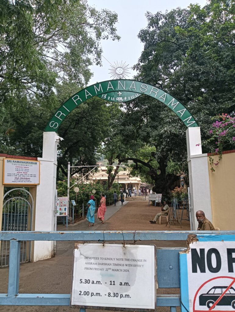 ラマナ・マハリシ・アシュラムの入り口ゲート。監視員が、ドレスコードや写真撮影、靴の預け入れなどのルールを確認している